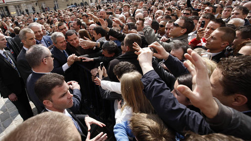President George W. Bush reaches out to the crowd Saturday during his visit to St. Mark's Square in Zagreb. More than 3000 people were on hand to welcome the President during his visit. White House photo by Eric Draper