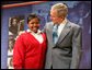 President George W. Bush stands with his arm around Aysia Mayo-Gray, a student at St. Ann's Academy in Washington, D.C., and one of the greeters on hand to welcome the President to the White House Summit on Inner-City Children and Faith-Based Schools Thursday, April 24, 2008, at the Ronald Reagan Building and International Trade Center. Said the President after being introduced by the 14-year-old, "Aysia, thanks for the introduction -- you did a fabulous job. I'm told that your's a very hard worker who loves school, and it's clear you always wear a smile." White House photo by Chris Greenberg