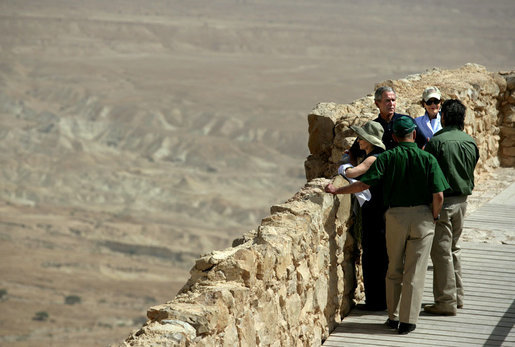 President George W. Bush and Mrs. Laura Bush and Prime Minister Ehud Olmert of Israel and Mrs. Aliza Olmert stand on the upper level of Masada, a palatial fortress built by King Herod, and listen to Eitan Campbell, Director of Masada National Park during their visit to the historic site Thursday, May 15, 2008. On the fringe of the Judean Desert near the shore of the Dead Sea, the camps, fortifications and assault ramp at its base constitute the most complete surviving ancient Roman siege system in the world. White House photo by Shealah Craighead