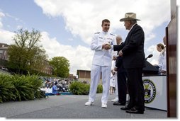 Vice President Dick Cheney presents commission papers to a U.S. Coast Guard Academy graduate, Wednesday, May 21, 2008, during commencement exercises in New London, Conn. During his address to the graduates the Vice President said, "This branch of the armed forces has given steady service to the United States of America since the year 1790 -- and in that time the Coast Guard has saved more than a million lives." He added, "As you step forward to accept new duties, your fellow citizens look up to you for the oath you take, the traditions you uphold, and the standards you live by." White House photo by David Bohrer