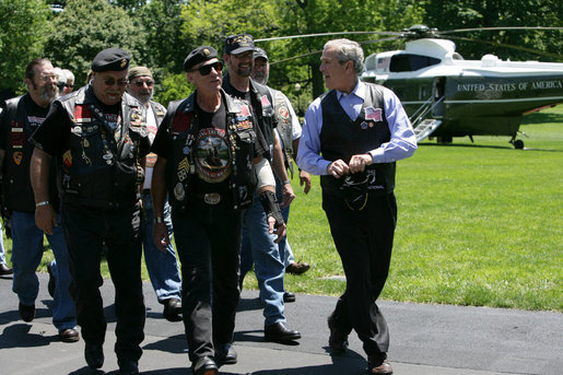 President George W. Bush shares a laugh with National Executive Director of Rolling Thunder Artie Muller as he escorts a group of the motorcyle riders to the Oval Office. White House photo by Chris Greenberg