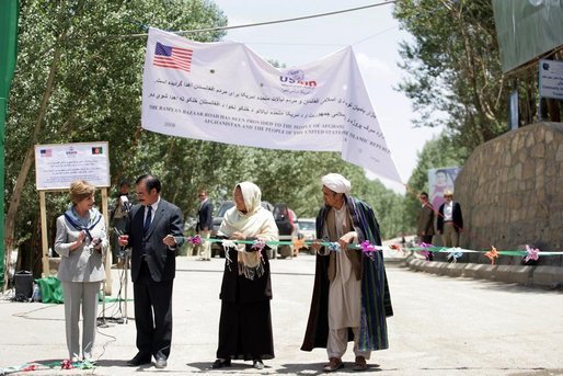 Mrs. Laura Bush, left, assists local officials with the ribbon cutting ceremony June 9, 2008 in Afghanistan at the ground-breaking ceremonies for the 1.96 kilometer Bamiyan road project through the bazaar. The new road will link up with a 1.72 kilometer road from the airport to the town center completed in 2007 with U.S. support. White House photo by Shealah Craighead