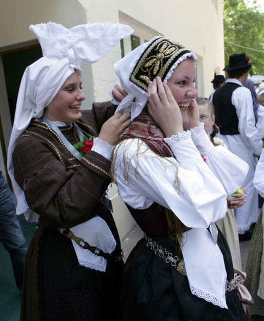 A girl helps her friend tie her head scarf as they wait for President George W. Bush's as he participates in a United States - European Union Working Lunch Tuesday, June 10, 2008, at the Brdo Congress Centre in Kranj, Slovenia. White House photo by Chris Greenberg