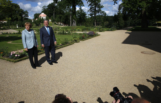 President George W. Bush and Germany's Chancellor Angela Merkel pause for photos during a walk in the garden Wednesday, June 11, 2008, during the President's visit to Schloss Meseberg, north of Berlin. The President met with Chancellor Merkel for a day of meetings before continuing his European visit with a stop in Rome. White House photo by Eric Draper