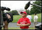 A player with the Cramer Hill Little League Red Sox of Camden, N.J., is the center of media attention on the South Lawn of the White House after playing Monday, June 30, 2008, in the opening game of the 2008 Tee Ball on the South Lawn, with his teammates against the Jose M. Rodriguez Little League Angels of Manati, Puerto Rico. White House photo by Chris Greenberg