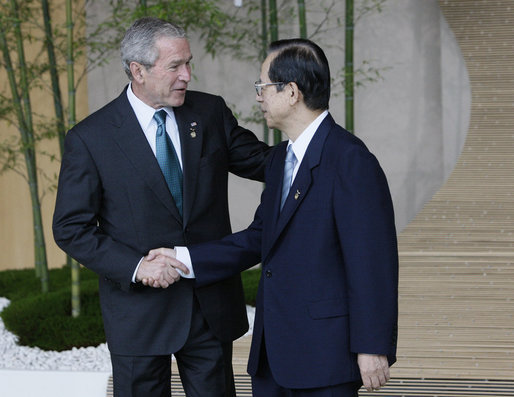 Prime Minister Yasuo Fukuda of Japan greets President George W. Bush as he arrives Monday, July 7, 2008, for the official G8 family photo in the grand lobby of the Windsor Hotel Toya Resort and Spa in Toyako, Japan. White House photo by Eric Draper