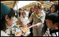 Mrs. Laura Bush tastes a sampling of the food at the Hokkaido Marche farmer's market in Makkari Village Tuesday, July 8, 2008, as part of the G-8 Spouses Program. The small village on the northern Japanese island of Hokkaido is known for its lilies and its potatoes, and the market, organized especially for the occasion of the G-8 Summit, showcased locally grown produce. White House photo by Shealah Craighead