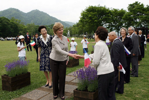 Mrs. Laura Bush, accompanied by Mrs. Kiyoko Fukuda, spouse of the Prime Minister of Japan, left, is greeted as she arrives to the Toyako New Mount Showa Memorial Park for a ceremonial tree planting ceremony with other G-8 spouses Wednesday, July 9, 2008, in Hokkaido, Japan. White House photo by Shealah Craighead
