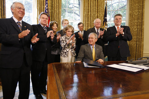President George W. Bush is applauded after signing H.J. Res. 93, the Renewal of Import Restrictions on Burma and H.R. 3890, the Tom Lantos Block Burmese JADE Act of 2008, Tuesday, July 29, 2008 in the Oval Office of the White House. Applauding President Bush are, from left, Rep. Don Manzullo, R-Ill.; Rep. Chris Smith, R-N.J.; Mrs. Laura Bush, Annette Lantos, widow of Rep. Tom Lantos; Lantos grandson, Shiloh Tillemann; Rep.Rush Holt, D-N.J.; Rep. Joe Pitts, R-Pa.; and Rep. Peter King, R-N.Y. White House photo by Eric Draper