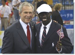 President George W. Bush poses for a photo with U.S. Olympic runner Lopez Lomong Friday, Aug. 8, 2008, in Beijing prior to Opening Ceremonies of the 2008 Summer Olympic Games. Lopez Lomong, a survivor of the violence in his native Sudan, now a U.S. citizen, was selected by his teammates to lead the U.S. Olympic team into Olympic National Stadium carrying the United States Flag at the Opening Ceremony. White House photo by Eric Draper