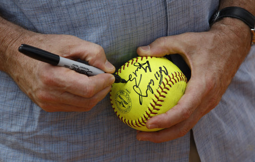 President George W. Bush autographs softball during the U.S. Women’s Softball practice Saturday, Aug. 9, 2008, at Fengtai Complex in Beijing. White House photo by Eric Draper