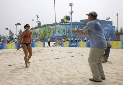 President George W. Bush hits a volleyball back to U.S. Women's Beach Volleyball team member Misty May-Treanor, left, during his visit to the Chaoyang Park practice courts Saturday, Aug. 9, 2008, before the U.S. team began their matches at the 2008 Summer Olympics in Beijing. White House photo by Eric Draper