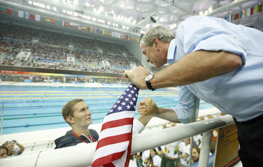 President George W. Bush shakes hands with U.S. swimmer Larsen Jensen after the 22-year-old won his bronze medal in the 400-meter freestyle Sunday, Aug. 10, 2008, at the 2008 Summer Olympics. White House photo by Eric Draper