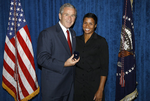 President George W. Bush stands with Keela Carr, a 35-year-old fitness and athletic trainer, shortly after his arrival Wednesday, Aug. 20, 2008, in Orlando, Florida. Ms. Carr was recognized by the U.S. Army's Freedom Team Salute Program and named its 500th Volunteer Ambassador in recognition of her 2008 2,700-mile, trans-America Journey of a Thousand Thanks to honor and thank all soldiers and veterans. White House photo by Eric Draper