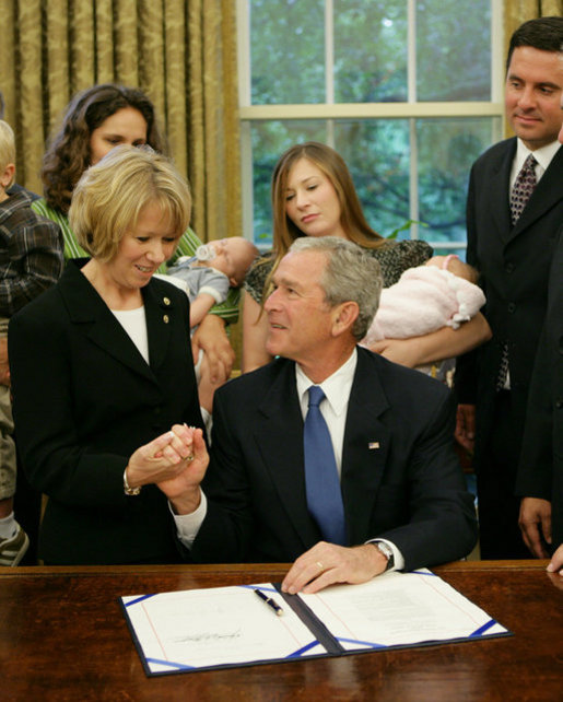 President George W. Bush holds the hand of Peggy Hubbard, mother of the Hubbard brothers, after signing H.R. 6580, The Hubbard Act, Aug. 29, 2008, in the Oval Office of the White House. The Hubbard Act is named in honor of brothers Jared and Nathan Hubbard , who lost their lives serving our country in Iraq. Their brother, Jason Hubbard was discharged from the Army as a sole survivor but was denied separation benefits. H.R. 6580 will provide sole survivors a number of benefits already offered to other soldiers honorably discharged from military service. White House photo by Chris Greenberg
