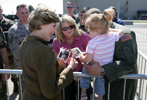 Mrs. Laura Bush offers photos of the Bush family dogs, Scottish Terrier's Barney and Miss Beazley, and the cat, Willie, to a little girl before departing from Forbes Field in Topeka, Kan., on Tuesday, Sept. 16, 2008. She had just greeted members of the military gathered to see her departure from the air field. White House photo by Chris Greenberg