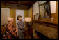 Mrs. Laura Bush looks at a portrait of Laura Ingalls Wilder and her husband on the Wilder home mantle Oct. 3., 2008, in Mansfield, Mo. Laura Ingalls married Almanzo Wilder in the summer of 1885 and moved to the Mansfield home where the "Little House" book series was written in 1894. Mrs. Jean Cody, Director and President of the Laura Ingalls Wilder Historic Home and Museum, explains that the mantle was something that the author really wanted to have. Her husband objected but obviously finally gave in. Wilder, who has been read by children and adults for over 70 years, is one of Mrs. Bush's favorite authors. The visit was used to help encourage American's to read their classic literature which defines us as a nation, reflects our history and bring us together by expressing our shared ideals. White House photo by Chris Greenberg