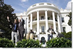 President George W. Bush is joined by Colombian musician Andres Cabas as they wave to invited guests, following Cabas and his band's performance Thursday, Oct. 9, 2008 on the South Lawn of the White House, during the celebration of Hispanic Heritage Month.  White House photo by Joyce N. Boghosian