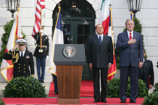 President George W. Bush and Prime Minister Silvio Berlusconi stand together on the reviewing stand Monday, Oct. 13, 2008 on the South Lawn of the White House, during the playing of the National Anthem. White House photo by Chris Greenberg