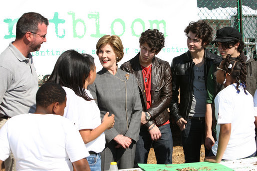 Surrounded by children participating in a soil sampling event, Mrs. Laura Bush speaks with Benjamin Jones, Director of Education, Trinity River Audubon Center, left during the First Bloom event at the Trinity River Audubon Center Sunday, November 2, 2008, in Dallas, TX. Mrs. Bush is joined by singer/songwriters the Jonas Brothers, Kevin Jonas, Joe Jonas, and Nick Jonas, right. White House photo by Chris Greenberg
