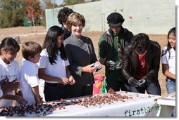 Surrounded by children Mrs. Laura Bush practices making seed balls during a First Bloom event at the Trinity River Audubon Center, Sunday, November 2, 2008, in Dallas, TX. Mrs. Bush is joined by singer/songwriters the Jonas Brothers, Kevin Jonas, Joe Jonas, and Nick Jonas, right.  White House photo by Chris Greenberg