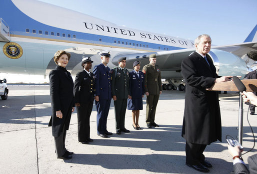 President George W. Bush, joined by Mrs. Laura Bush, stands outside Air Force One as he addresses his remarks in honor of Veterans Day, Tuesday, Nov. 11, 2008 upon the President's arrival at John F. Kennedy International Airport in New York. President Bush introduced military personnel representing the five branches of the armed services, who traveled with him aboard AF-1, honoring their service, from left are, U.S. Navy Chief Petty Officer Shenequa Cox of Dallas, Texas; U.S. Coast Guard Petty Officer First Class Christopher O. Hutto of Homer, Alaska; U.S. Army National Guard SSgt Michael Noyce-Merino of Melrose, Montana; U.S. Air Force Senior Airman Alicia Goetschel of Warrensburg, Mo., and U.S. Marine Corps Sgt. John Badon of Lufkin, Texas. White House photo by Eric Draper