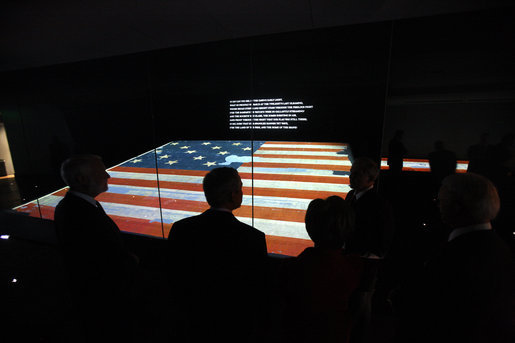 President George W. Bush is silhouetted against the renovated Star-Spangled Banner American flag exhibit Wednesday, Nov. 19, 2008, during his visit with Mrs. Laura Bush to the National Museum of American History in Washington, D.C. The flag, which flew above Fort McHenry in Baltimore during the British attack in 1814, inspired Francis Scott Key to write the lyrics that became our national anthem. White House photo by Eric Draper