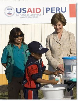 Mrs. Laura Bush and Ms. Nancy Quispitupa, Program Manager and Community Trainer, watch as 8-year-old William Sebastian Hernandez Jeri demonstrates learned hand-washing techniques Friday, Nov. 21, 2008, at the San Clemente Health Center in San Clemente, Peru. The center is the town's major health provider and serves an average of 80 patients per day.  White House photo by Joyce N. Boghosian