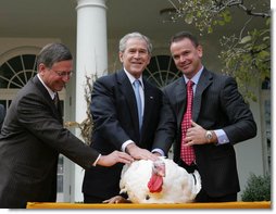 President George W. Bush stands between Paul Hill, left, of the National Turkey Federation, and his son, Nathan Hill during the pardoning of the Thanksgiving turkey Wednesday, Nov. 26, 2008, in the Rose Garden of the White House. This year marked the 61st anniversary of the National Thanksgiving Turkey Presentation and Pardoning.  White House photo by Joyce N. Boghosian
