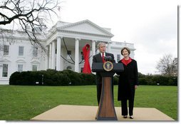 President George W. Bush and Mrs. Laura Bush address reporters on World AIDS Day from the the North Lawn of the White House, Monday, Dec. 1. 2008, where President Bush reaffirmed the commitment to fight HIV/AIDS at home and abroad. A large red ribbon is displayed from the North Portico of the White House in observance of World AIDS Day. White House photo by Joyce N. Boghosian