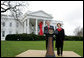 President George W. Bush and Mrs. Laura Bush address reporters on World AIDS Day from the North Lawn of the White House, Monday, Dec. 1. 2008, where President Bush reaffirmed the commitment to fight HIV/AIDS at home and abroad. A large red ribbon is displayed from the North Portico of the White House in observance of World AIDS Day. White House photo by Joyce N. Boghosian