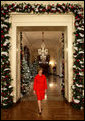 Mrs. Laura Bush walks from the White House Cross Hall into the East Room, Wednesday, Dec. 3, 2008, to begin the Christmas press preview of the White House decorations and preparations. White House photo by Chris Greenberg