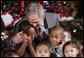 President George W. Bush embraces a group of youngsters Monday, Dec. 8, 2008, as he welcomes children attending the Children's Holiday Reception and Performance at the White House. White House photo by Eric Draper