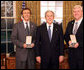 President George W. Bush stands with Jeff Miller and Earl Morse after presenting them with the 2008 Presidential Citizens Medal Wednesday, Dec. 10, 2008, in the Oval Office of the White House. White House photo by Chris Greenberg