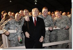 President George W. Bush pauses for photos with troops at Bagram Air Base Monday, Dec. 15, 2008, in Afghanistan. The President made the pre-dawn visit to the base before meeting with President Hamid Karzai in Kabul. During his remarks to the troops, the President said, "What you're doing in Afghanistan is important, it is courageous, and it is selfless. It's akin to what American troops did in places like Normandy and Iwo Jima and Korea. Your generation is every bit as great as any that has come before. And the work you do every day is shaping history for generations to come."  White House photo by Eric Draper