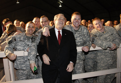 President George W. Bush pauses for photos with troops at Bagram Air Base Monday, Dec. 15, 2008, in Afghanistan. The President made the pre-dawn visit to the base before meeting with President Hamid Karzai in Kabul. During his remarks to the troops, the President said, "What you're doing in Afghanistan is important, it is courageous, and it is selfless. It's akin to what American troops did in places like Normandy and Iwo Jima and Korea. Your generation is every bit as great as any that has come before. And the work you do every day is shaping history for generations to come." White House photo by Eric Draper