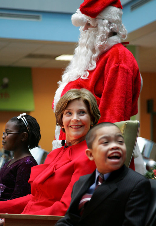 Mrs. Laura Bush watches Barney Cam VII: A Red, White & Blue Christmas as it debuts for children at Children's National Medical Center in Washington, D.C. on Dec. 15, 2008. With Mrs. Bush are her two patient escort volunteers, Dania Jecty, left, age 11, and Elmer Reyes, age 13. Visiting the hospital is an annual tradition for Mrs. Bush, and one she says she will miss. White House photo by Joyce N. Boghosian