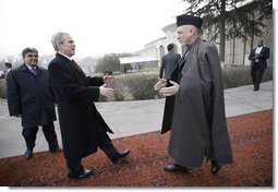 President George W. Bush is greeted by President Hamid Karzai upon arrival Monday morning, Dec. 15, 2008, at the Afghanistan leader's presidential palace in Kabul.  White House photo by Eric Draper