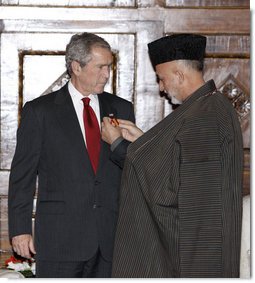President George W. Bush is presented the Ghazi Amir Amanullah Khan Insignia by Afghanistan's President Hamid Karzai Monday, Dec. 15, 2008, for his efforts in rebuilding the country. The presentation came during a surprise visit to Kabul about which the President said, "I want to be in Afghanistan to say 'thank you' to President Karzai, to let the people of Afghanistan know that the United States has stood with them and will stand with them."  White House photo by Eric Draper