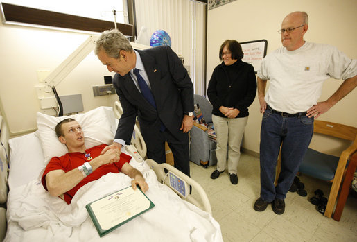 President George W. Bush shakes the hand of U.S. Army PFC Lukas Shook of Strafford, Mo., after presenting him with a Purple Heart Monday, Dec. 22, 2008, during a visit to Walter Reed Army Medical Center, where the soldier is recovering from injuries received in Operation Iraqi Freedom. Looking on are PFC Shook's mother and father, Dennis and Cynthia Shook. White House photo by Eric Draper