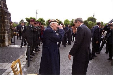 President Bush salutes a veteran during a Memorial Day service at the Saint Marie Eglise Church in Saint Marie Eglise, near Normandy, France, May 27.