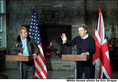 President Bush and Prime Minister Tony Blair stand in front of the U.S. and British flags. White House photo by Eric Draper.