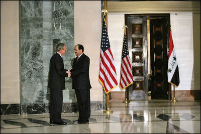 Prime Minister Nouri al-Maliki greets President George W. Bush upon his arrival to Baghdad, Iraq, Tuesday, June 12, 2006. White House photo by Eric Draper 