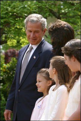 President George W. Bush looks toward Lacy Lyons, center, before signing the S. 151, PROTECT Act of 2003, in the Rose Garden Wednesday, April 30, 2003. Abducted by their father, Lacy, 10, and her sister Nyoka, 8, left, were found after an AMBER alert was activated throughout the state of Florida. 