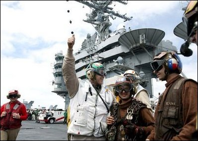 After a successful landing, President George W. Bush gives the thumbs-up sign as he meets with flight crews on the deck of the USS Abraham Lincoln Thursday, May 1, 2003. 