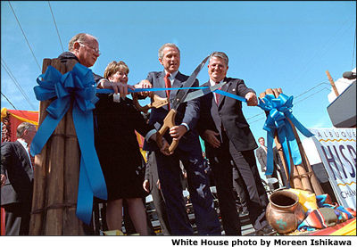 With help from officials from Albuquerque's Hispanic Chamber of Commerce, President Bush cuts the ribbon to open the Barelas Job Opportunity Center Aug 15. White House photo by Moreen Ishikawa.