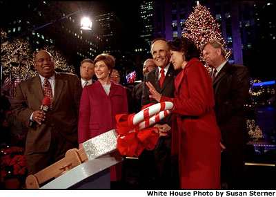 After throwing the switch to light up the Christmas tree at Rockefeller Center, Mrs. Bush sings Christmas carols with New York Mayor Rudolph Guiliani, center, and Today Show anchors Al Roker, far left, and Ann Curry, far right, in New York City Nov. 28. White House photo by Susan Sterner.