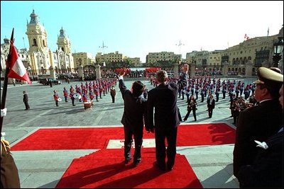 President George W. Bush and Peruvian President Alejandro Toledo (right) wave from the steps of the Presidential Palace in Lima, Peru, March 23, 2002. White House photo by Eric Draper