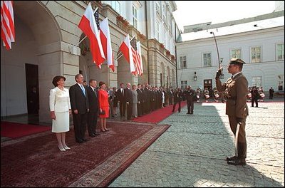 President George W. Bush and Laura Bush participate in an arrival ceremony with President Kwasniewski and his wife, Jolanta. Honoring both leaders, the national anthems of the two countries were played. Afterwards, the two Presidents reviewed the troops. 