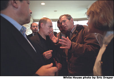 President George W. Bush and Russian President Vladimir Putin meet as Russian and White House staff listen moments before the departure of President and Mrs. Putin from the Bush Ranch, Thursday, Nov. 15, 2001. White House photo by Eric Draper.